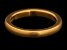 A 22 carat gold ring,: the plain polished band, stamped 22 with full Birmingham hallmarks,