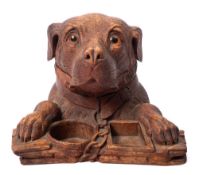 A Black Forest carved linden wood smoker's companion: in the form of a dog's head and paws resting