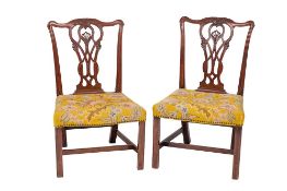 A pair of George III carved mahogany dining chairs in the Chippendale taste: the backs with