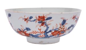A Chinese Imari bowl: painted with knarled branches of blossom and a large butterfly,