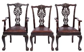 A set of four carved stained beech dining chairs in the Chippendale taste,