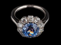 A purple sapphire and diamond ring,: the central circular cut purple sapphire, estimated to weigh 4.