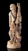 A Japanese ivory okimono of a peasant farmer: holding a basket of grapes,