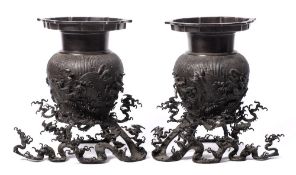 A pair of Chinese bronze vases and stands: each of ovoid form with cylindrical neck and lotus