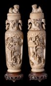 A pair of Chinese carved ivory vases with covers: of ovoid form with covers surmounted by temple