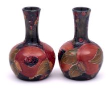 A pair of William Moorcroft miniature bottle vases: each tube-lined and decorated in the