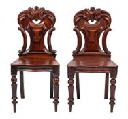 A pair of Victorian carved mahogany hall chairs:,