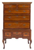 An 18th Century elm and crossbanded chest on stand:, the upper part with a moulded cornice,