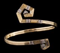 A diamond-set bangle of scroll design,: the terminals set with eight cut diamonds, on a reeded band,