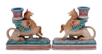 A pair of Royal Worcester majolica Griffin candlesticks: each winged griffin supporting a