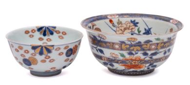 Two Japanese Imari bowls: the larger with flared rim and painted overall with peony, chrysanthemum,