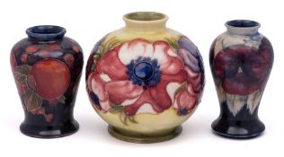 A group of three William Moorcroft vases: comprising a miniature baluster vase in the 'Pansy'