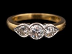 An 18 carat gold and diamond three stone ring,: the central brilliant cut diamond,