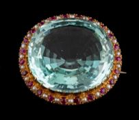 An aquamarine, ruby and seed pearl brooch,: the oval cut aquamarine, estimated to weigh 49.