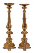 A pair of Italianate gilt brass candlesticks: the urn-shaped sconces with foliate decoration,