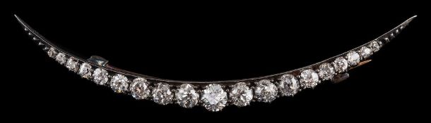 A diamond crescent brooch,: set with graduated old European cut diamonds, approximately 1.