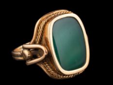 A dyed green agate ring,: the agate panel in collet setting, with a ropetwist surround,