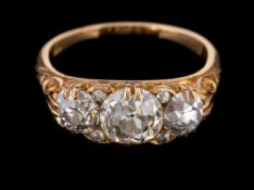 A three stone diamond ring,: the central old brilliant cut diamond, estimated to weigh 1.