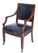 An Edwardian mahogany library armchair:, the upholstered panel back with fluted top rail,