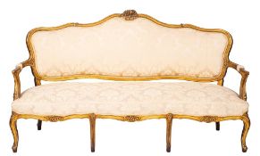 A salon suite of four carved and giltwood and damask upholstered bergères and a canapé in Louis XV