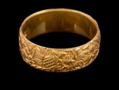 An 18 carat gold ring,: the band with foliate decoration,