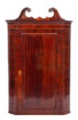 A George III mahogany and inlaid hanging corner cupboard:, bordered with boxwood lines,