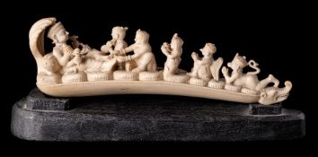 An Indian carved ivory figure group: of a diety reclining on coiled snakes with musicians and