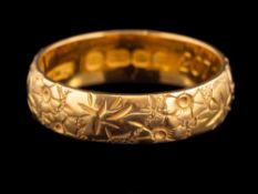 A 22 carat gold ring,: the band with chased foliate decoration,