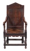 A 17th Century and later oak open armchair:, the panelled back with angled arch cresting,