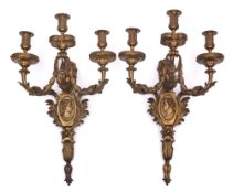 A pair of gilt ormolu three-branch wall appliques: the urn-shaped nozzles decorated with acanthus