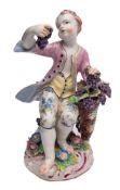 A Bow figure of Autumn: the seated boy wearing a pink jacket and floral breeches,