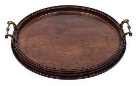 A Georgian mahogany serving tray: of circular outline with moulded border and brass loop carrying