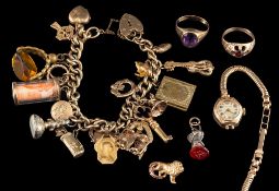 A charm bracelet,: the curb link chain with various charms, including a heart locket, a key, fobs,