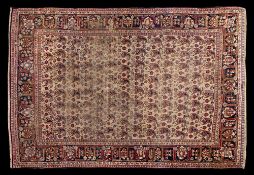 A Feraghan rug:, the beige field with repeated boteh medallions,