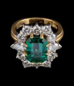 An 18 carat gold emerald and diamond ring,: the central rectangular cut emerald stated to weigh 3.