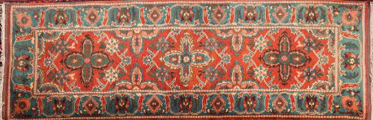 An Iranian runner:, the brick red field with triple geometric flowerhead medallions,