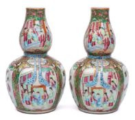A pair of Chinese Canton double gourd famille rose vases: the necks relief moulded with turquoise
