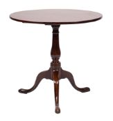 A George III mahogany circular tea table:, with a snap top on ring turned baluster column,
