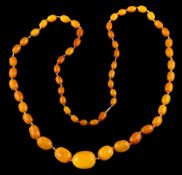 An amber bead necklace,: the graduated 27mm to 10mm amber beads on a knotted thread, 94cm long,