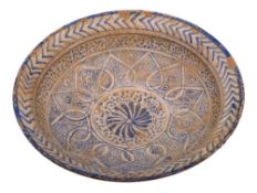 A Persian pottery dish: of shallow circular form with everted rim,