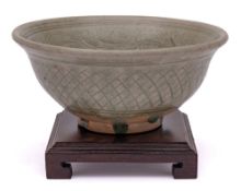 A Thai Sawankhalok celadon glazed bowl: the interior incised with a band of scrolling foliage