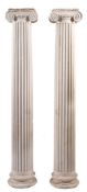 A pair of composition plaster fluted columns:, with Ionic capitals, on circular bases,