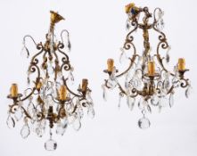 A pair of gilt metal and cut glass hung four-light chandeliers in Louis XV style,