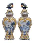 A pair of Dutch polychrome delftware vases and covers: with parrot and fruit finials,