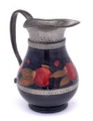 A William Moorcroft pewter mounted jug: decorated in the Pomegranate pattern, the mounts hammered,