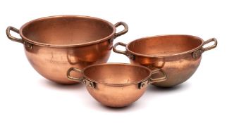 A set of three graduated copper cauldrons: with brass loop carrying handles to the sides, 27.