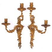 A pair of 19th century French gilt brass twin-light wall sconces: the urn-shaped sconces on