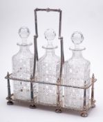 An Edwardian silver plated three decanter stand: of rectangular outline with beaded decoration and