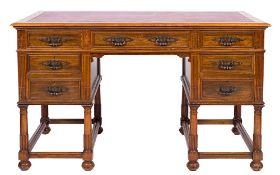 An Edwardian walnut kneehole desk:, the rectangular moulded top inset with a panel of faux leather,