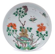 A Chinese famille verte saucer dish: painted with two butterflies flying above tree peonies issuing